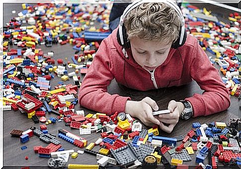 Boy with lego, headphones and phone