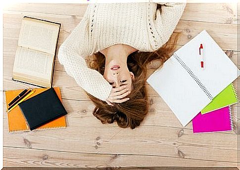 Tired woman on the floor with books