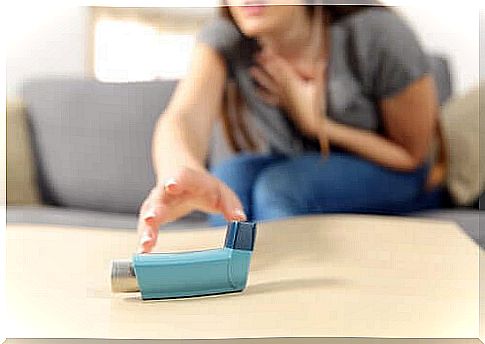 A woman reaching for her inhaler