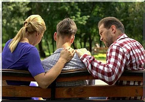 Three people sitting on a bench.