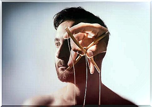 Marionette strings in front of a man's face, which shows that brainwashing is real.