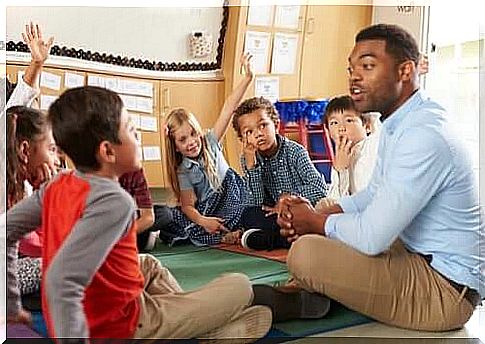 Teacher surrounded by children in classroom.