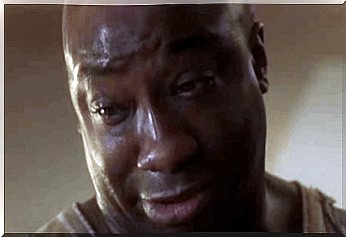 John Coffey in The Green Mile looks down, with tears in his eyes.