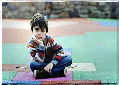 Boy sits on colorful ground