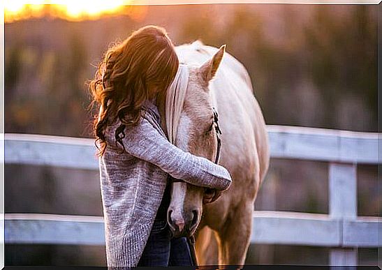 woman hugging horse